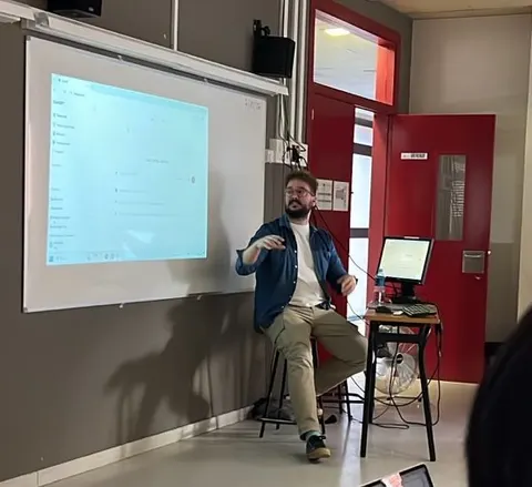 Oriol dando una formación al profesorado de una escuela, con la pantalla proyectada