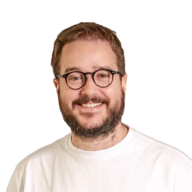 Oriol Piqué, programador de software a medida con IA, sonriendo, con gafas y camiseta blanca