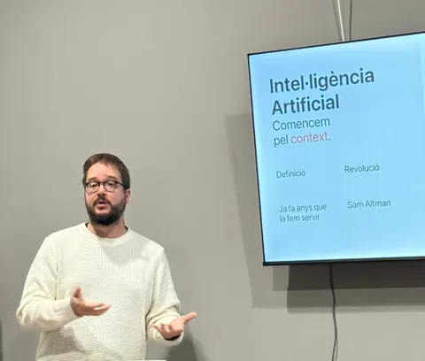 Oriol dando una charla sobre inteligencia artificial en Castelldans, con la diapositiva detrás